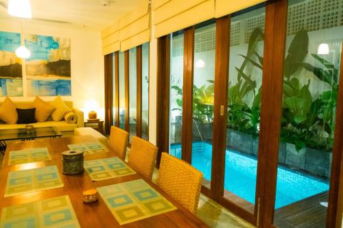 a living room with a table and a swimming pool at Vintage 83 Tangalle in Tangalle