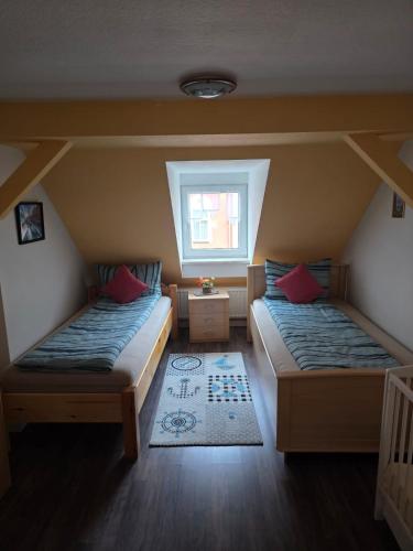 ein Zimmer mit zwei Betten und einem Fenster in der Unterkunft Flonta Ferienwohnung in Mittweida