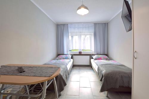 a room with two beds and a table at Gospodarstwo Zacisze in Kowary