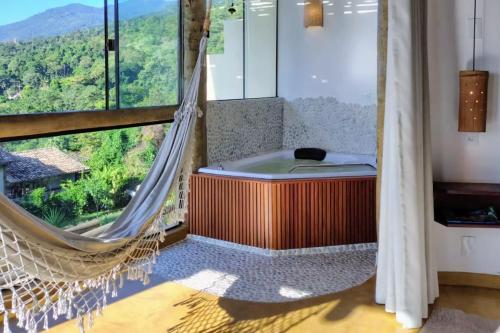 a hammock in a room with a view at OPN Guest House Ilhabela in Ilhabela