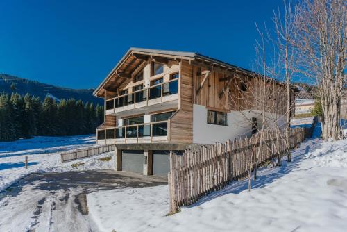 a log home in the snow with a fence at Schlicki's Bergchalet in Filzmoos
