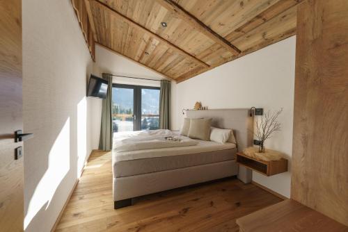 a bedroom with a bed and a wooden ceiling at Schlicki's Bergchalet in Filzmoos