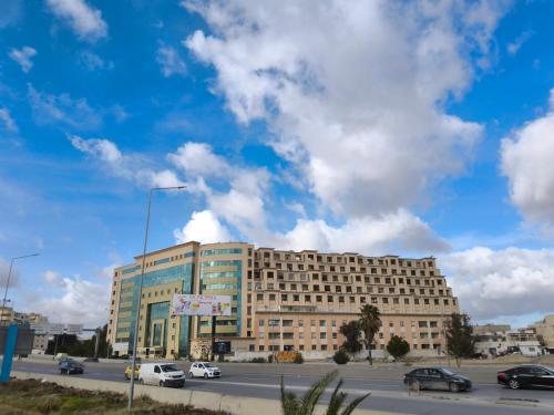 a large building with cars parked in a parking lot at Résidence Tunis Carthage in Ariana