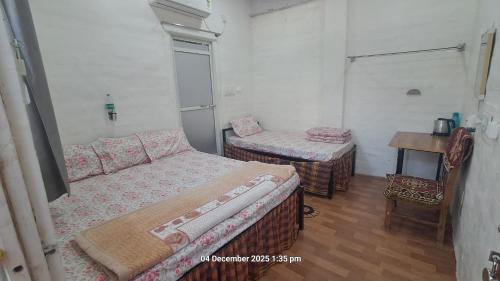 a bedroom with a bed and a table and a chair at Sitaram Atithi Grha in Godarpura
