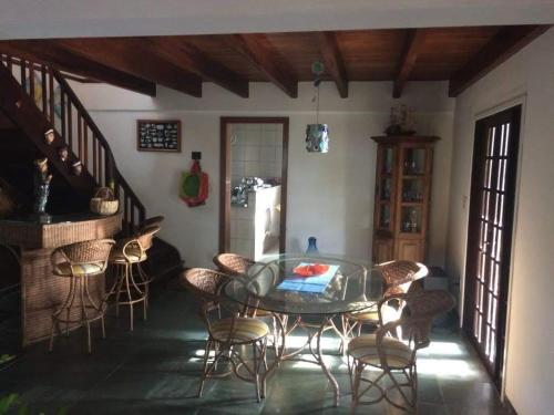 a dining room with a glass table and chairs at Lorena'Haus in Bombinhas