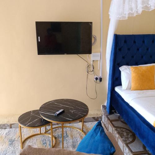 a room with a bed and a tv and a table at Maureen Homes Bomet in Bomet