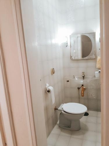 a small bathroom with a toilet and a mirror at Apartamento Solaris in Cunha