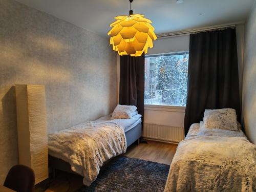 a bedroom with two twin beds and a window at Tievastreet Harmony Apartment in Rovaniemi