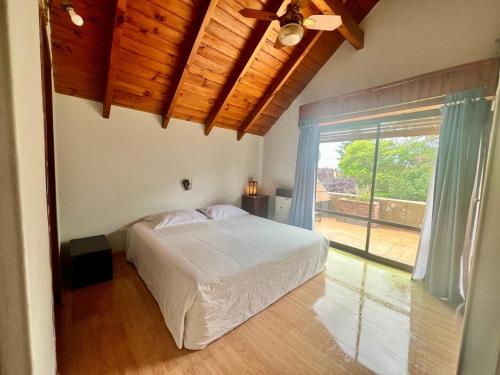 una camera da letto con un letto e una grande finestra di Espacio de Calma a La Falda