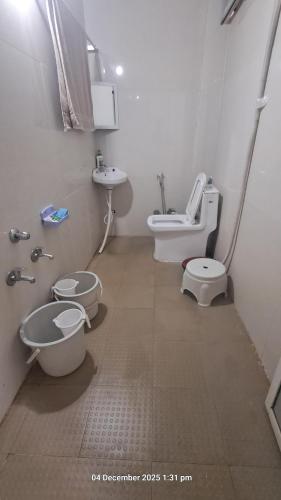 a bathroom with a toilet and a sink and a toilet istg at Sitaram Atithi Grha in Godarpura