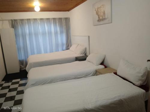 a bedroom with two beds and a checkered floor at Quigney House on 66 Rhodes in East London