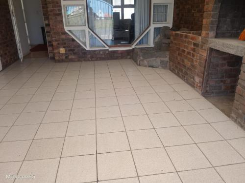a tiled floor in a room with a window at Quigney House on 66 Rhodes in East London