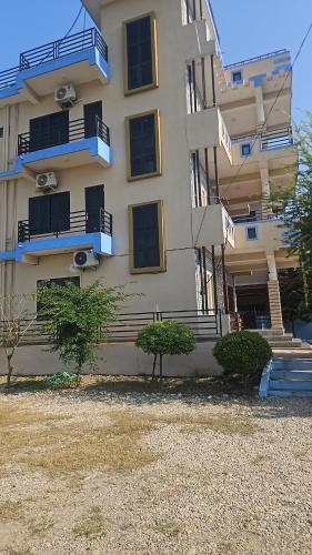 un bâtiment avec des balcons et des arbres devant lui dans l'établissement Cozy house, à Sauraha