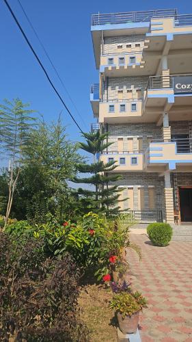 Un bâtiment avec beaucoup de plantes devant lui dans l'établissement Cozy house, à Sauraha