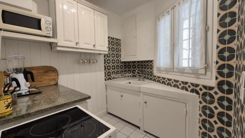 Rose في لو لا فاندو: مطبخ بخزائن بيضاء ومغسلة ونافذة