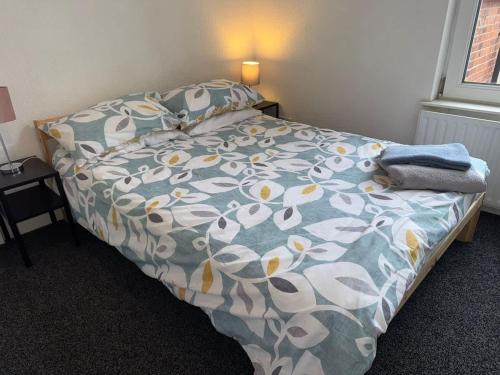 a bedroom with a bed with a floral comforter at Lovely Central Belfast 4 Bedroom Period Home in Belfast