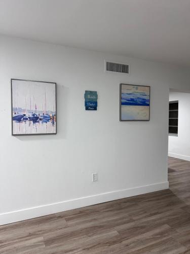 a white room with three paintings on a wall at CG Miami House in Miami