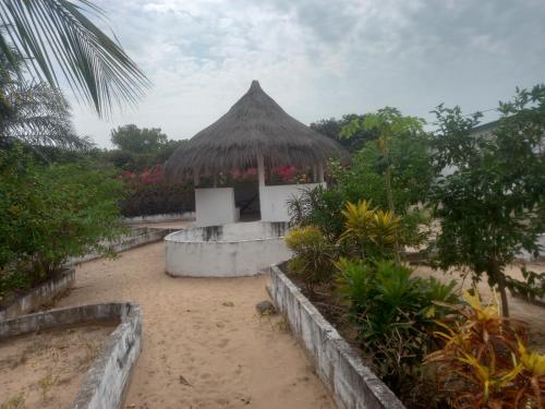 een klein gebouw met een strooien hut op een strand bij Hôtel auberge Sankaranka in Abémé