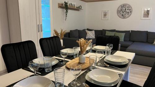 una sala da pranzo con un tavolo con piatti e bicchieri da vino di Zum Rosenhügel a Hellenthal