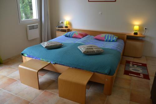 a bedroom with a bed with two pillows on it at Villa Pepy in Salviac