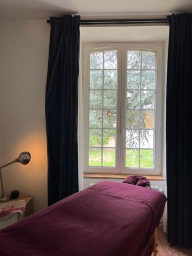 Un dormitorio con una cama morada y una ventana. en Le SAN - Chambre d'hôtes INCLUSIVE & ÉCORESPONSABLE, en Beauchery