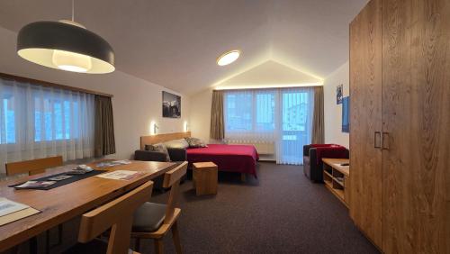 a hotel room with a desk and a bed and a room at Haus Aida in Saas-Fee