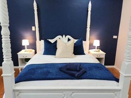 2 Seconds Avenue في هيلتون: غرفة نوم بسرير ابيض بجدران زرقاء