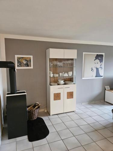 a kitchen with a white refrigerator and a tile floor at Design Wohnung in Petersdorf auf Fehmarn