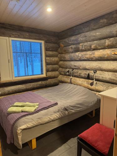 a bedroom with a bed in a log cabin at Aurora Forest Lodge Ylläs in Äkäslompolo