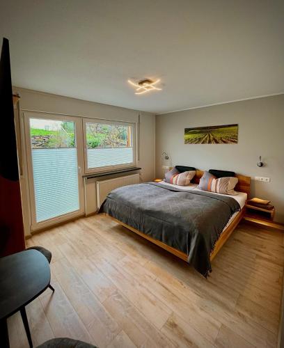 a bedroom with a large bed and two windows at Steinfelderhof in Kröv