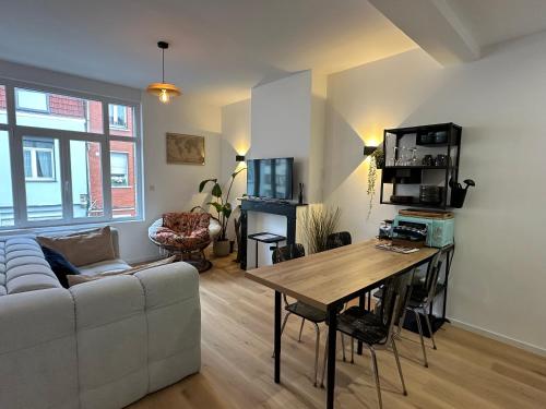 a living room with a couch and a table at Appartement standing 500m de la plage ! in Dunkerque