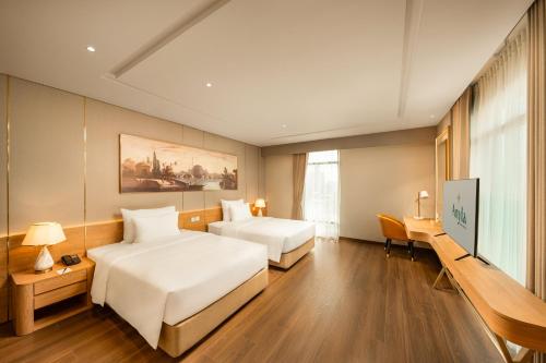 a hotel room with two beds and a flat screen tv at Anyla Grand Hotels in Thanh Hóa