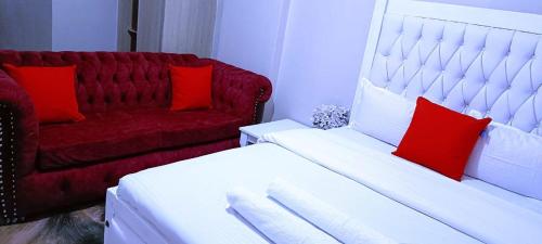 Una sala de estar con un sofá y almohadas rojas. en Kwa Engineer, en Wajir