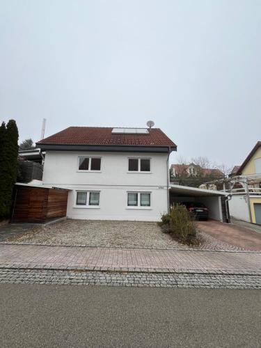 Ferienwohnung Nähe Autobahn Ruhige Lage für Familien & Monteure في Erolzheim: بيت أبيض بسقف أحمر