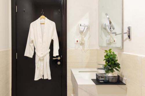 a white robe hanging on a door in a bathroom at كنكون - Cancun in King Abdullah Economic City