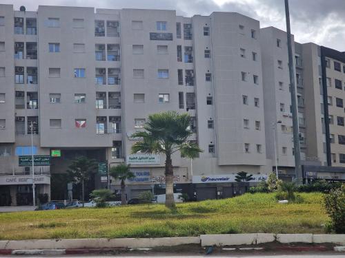 K2 Cliniques Jasmins Pasteur Cartagène في تونس: نخلة أمام مبنى كبير