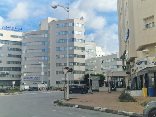 K2 Cliniques Jasmins Pasteur Cartagène في تونس: شارع المدينة فيه مبنى كبير في الخلف