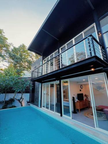 a house with a swimming pool in front of a house at 3BR Villa mit Pool, Villa Jovino, Jameja Kerobokan in Kerobokan