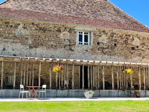 Un edificio en construcción con una mesa y sillas. en Luxe caravan met rust, ruimte en uitzicht, en Saint-Sulpice-dʼExcideuil