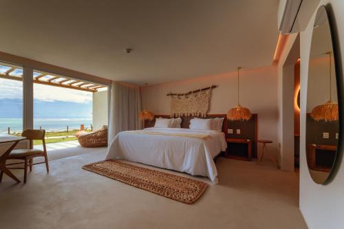 a bedroom with a bed with a view of the ocean at Pousada Aysú in Japaratinga