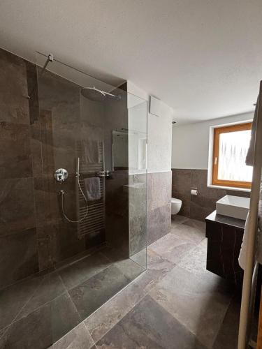 ein Badezimmer mit Dusche mit Glastür in der Unterkunft Hotel Laerchenhain in Sankt Valentin auf der Haide