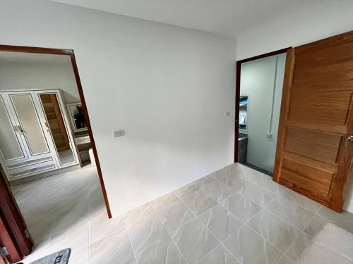 una habitación vacía con espejo y puerta en Chaloklum Garden House, en Ko Pha Ngan