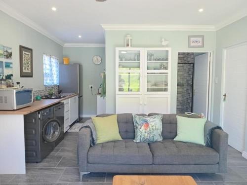 a living room with a couch and a kitchen at Zebra Crossing in Bushmans River Village