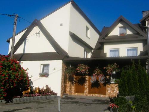 una casa bianca con cancello e fiori di Biesiada a Czarna Góra