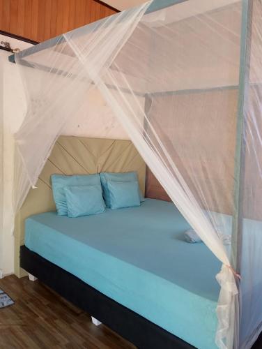 a bed with a canopy in a room at Naca Homestay in Manado