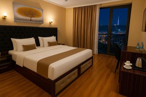 a hotel room with a large bed and a window at Hotel Residence Plaza in Tbilisi City