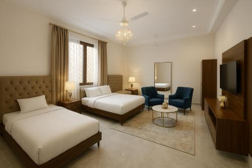 a hotel room with two beds and a television at Takery Resort in Chittaurgarh