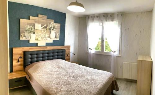 a bedroom with a large bed and a window at La petite cauchoise in Bacqueville-en-Caux