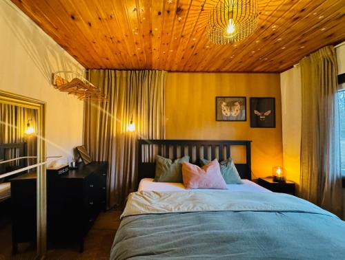 a bedroom with a large bed with a wooden ceiling at La Clairiere - Erezee- 3 bedroom chalet in Érezée