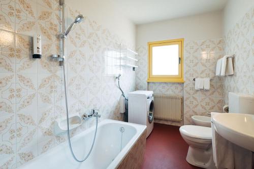 ein Badezimmer mit Badewanne, Toilette und Waschbecken in der Unterkunft MiraOdle Apartments in Villnöß